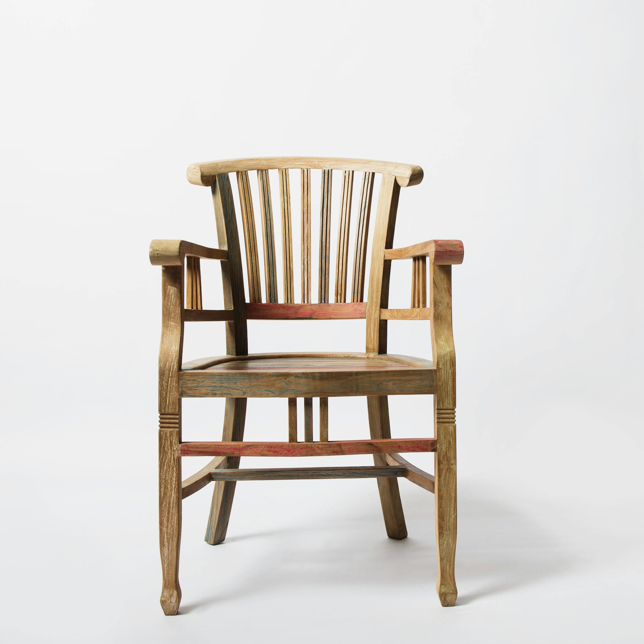 A vintage wooden armchair with intricate design sits on a white background.
