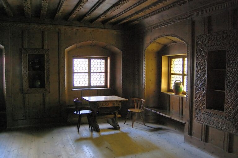 Charming rustic room with wooden interior and ornate carvings, featuring vintage furniture.