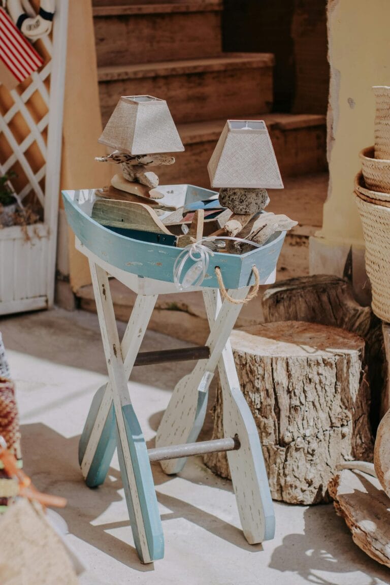 Vintage wooden table with lamps and logs creates a rustic outdoor ambiance.